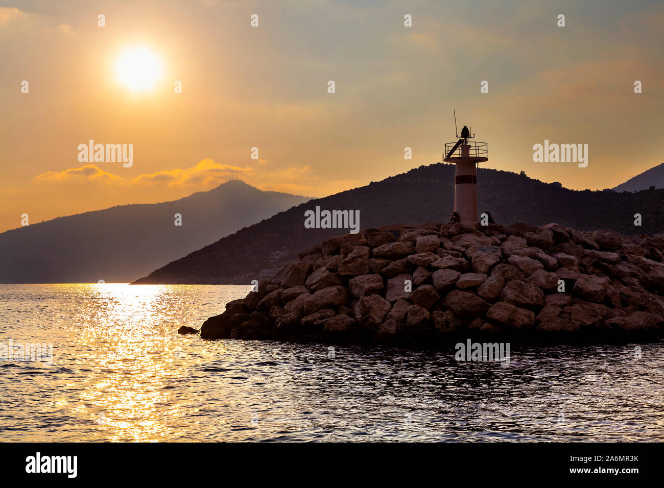 Der Leuchtturm bei Sonnenuntergang im Hafen der Stadt und beliebtes Reiseziel von Kalkan, Türkische Riviera, Türkei Stockfoto