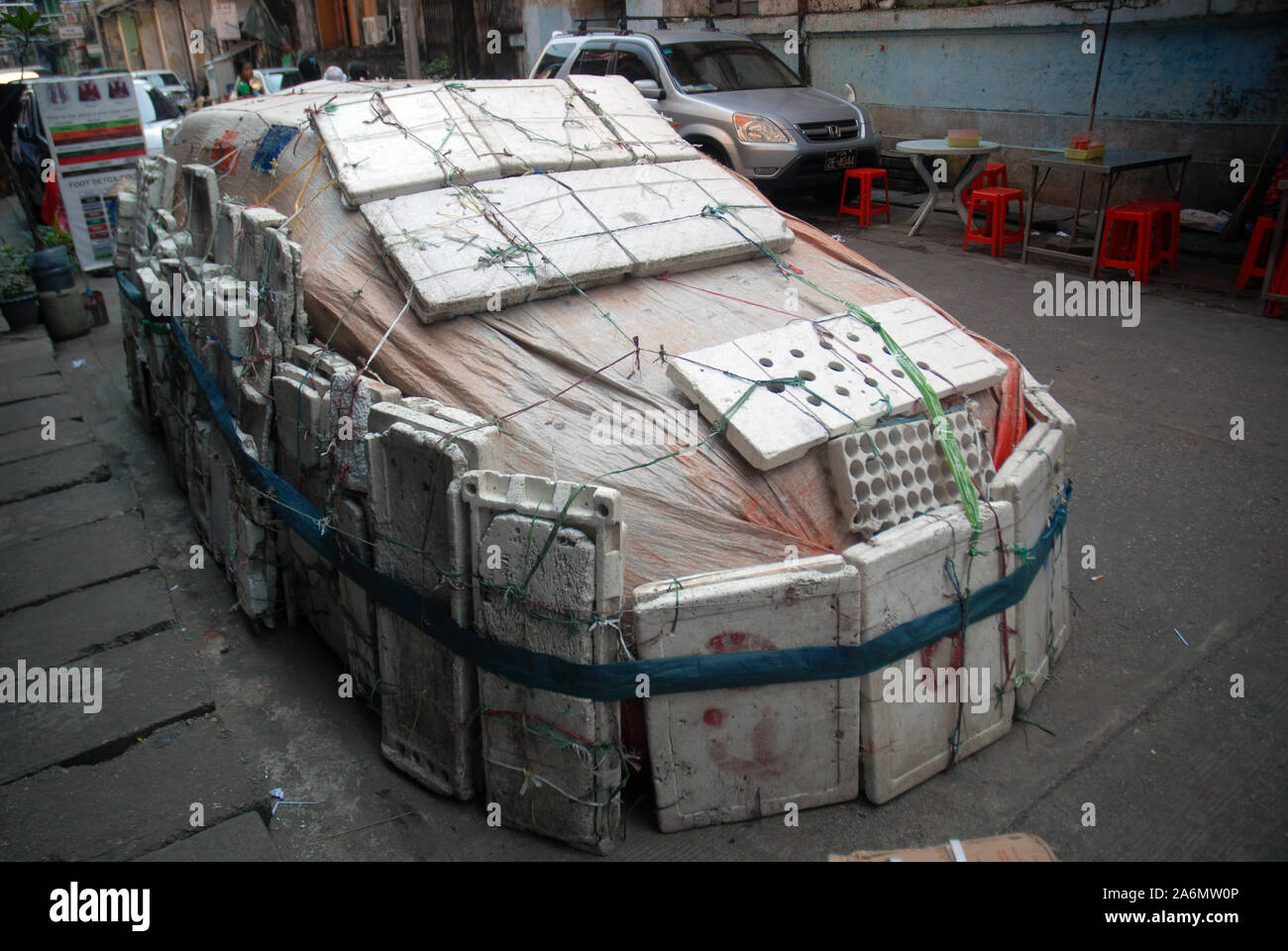 Auto geschützt von Elementen mit Bausteinen aus Styropor, Yangon, Myanmar, Asien. Stockfoto