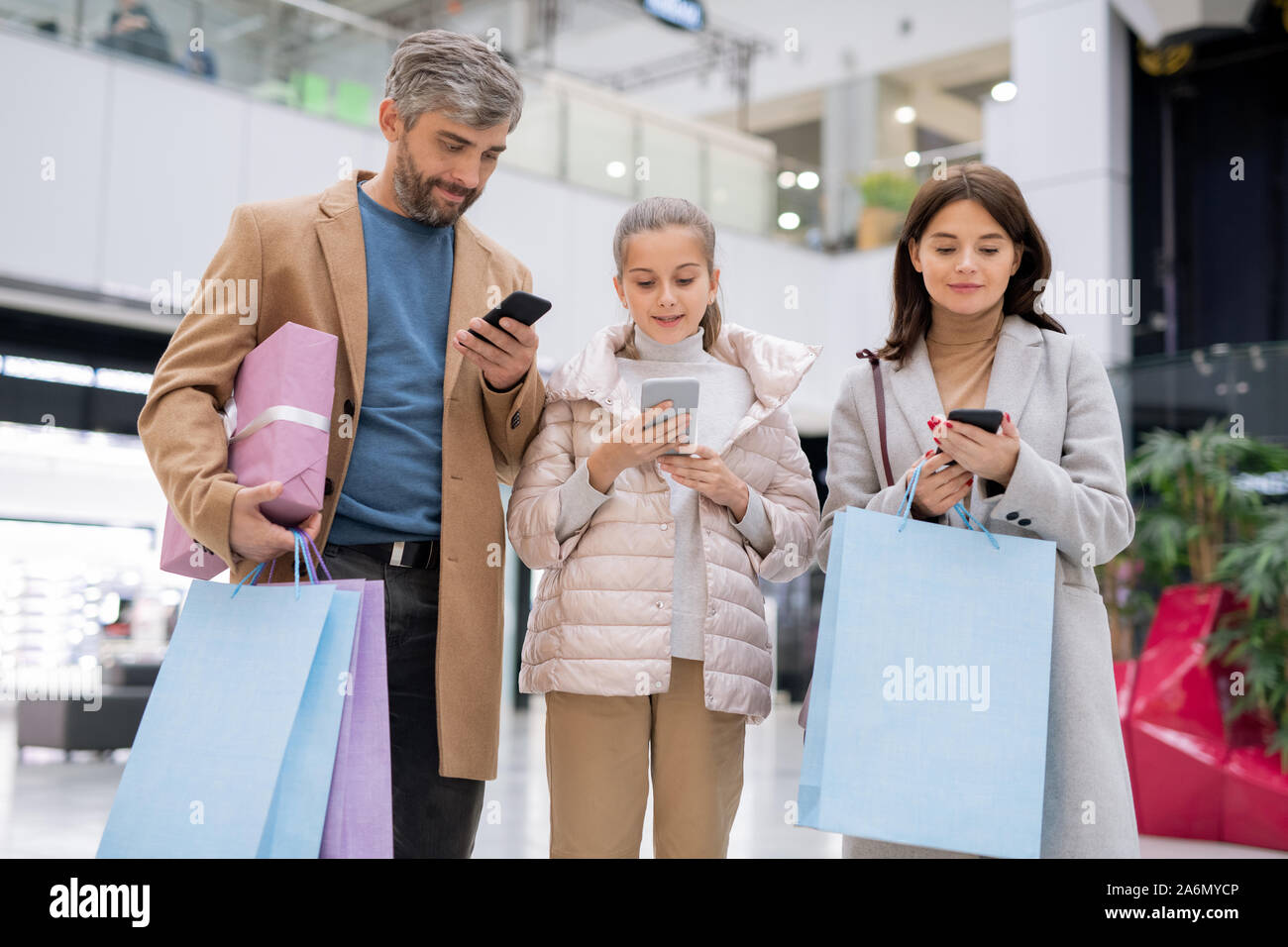 Mobile Familie mit ihren Smartphones beim Blättern durch on-line-Geschäfte Stockfoto