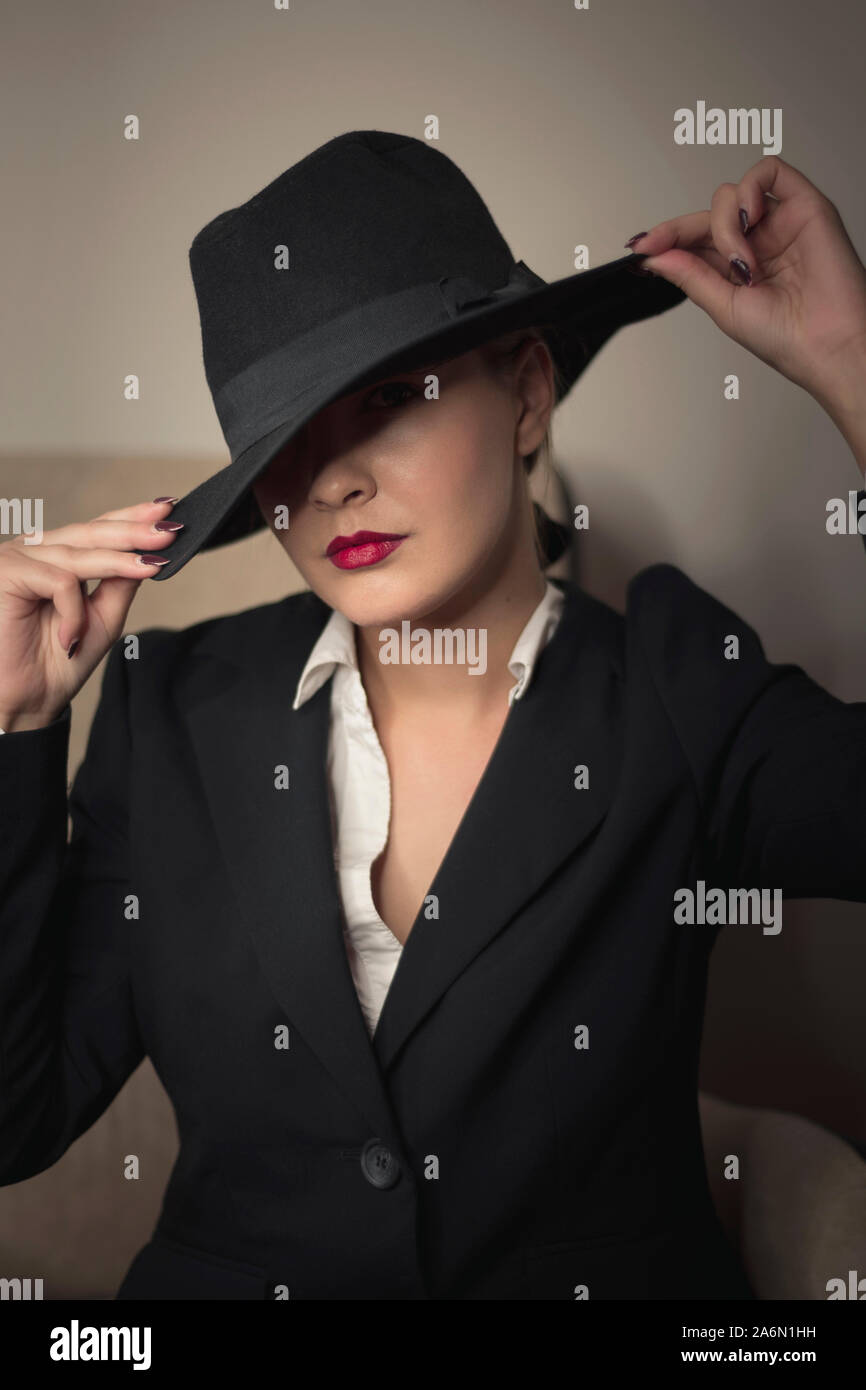 Junge Frau in schwarzer Kleidung mit Hut Porträt Stockfoto