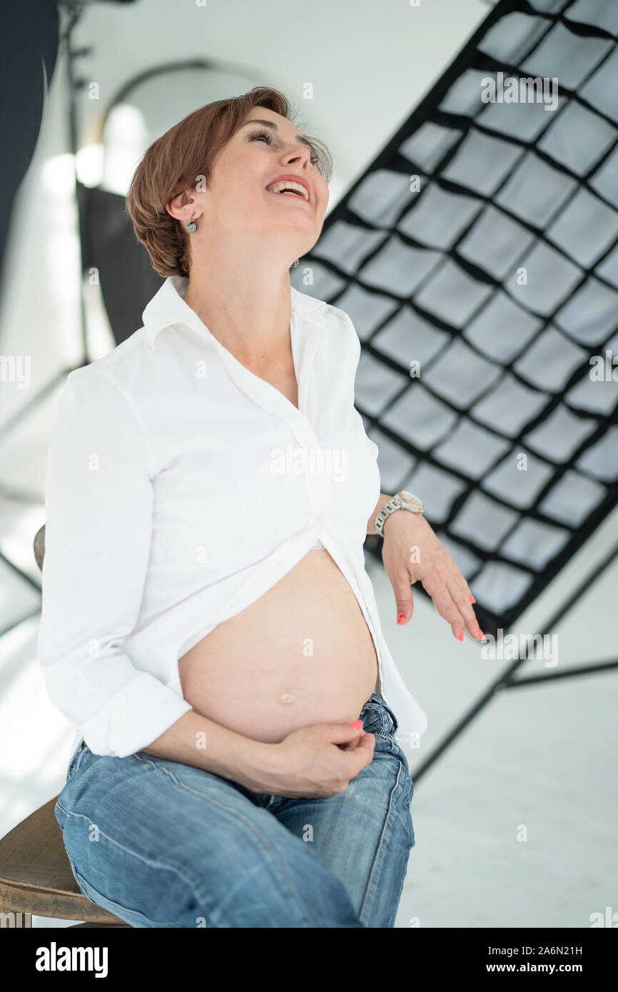 Baby Erwartung Glück. Schwangere Mama lacht in die Kamera. Stockfoto