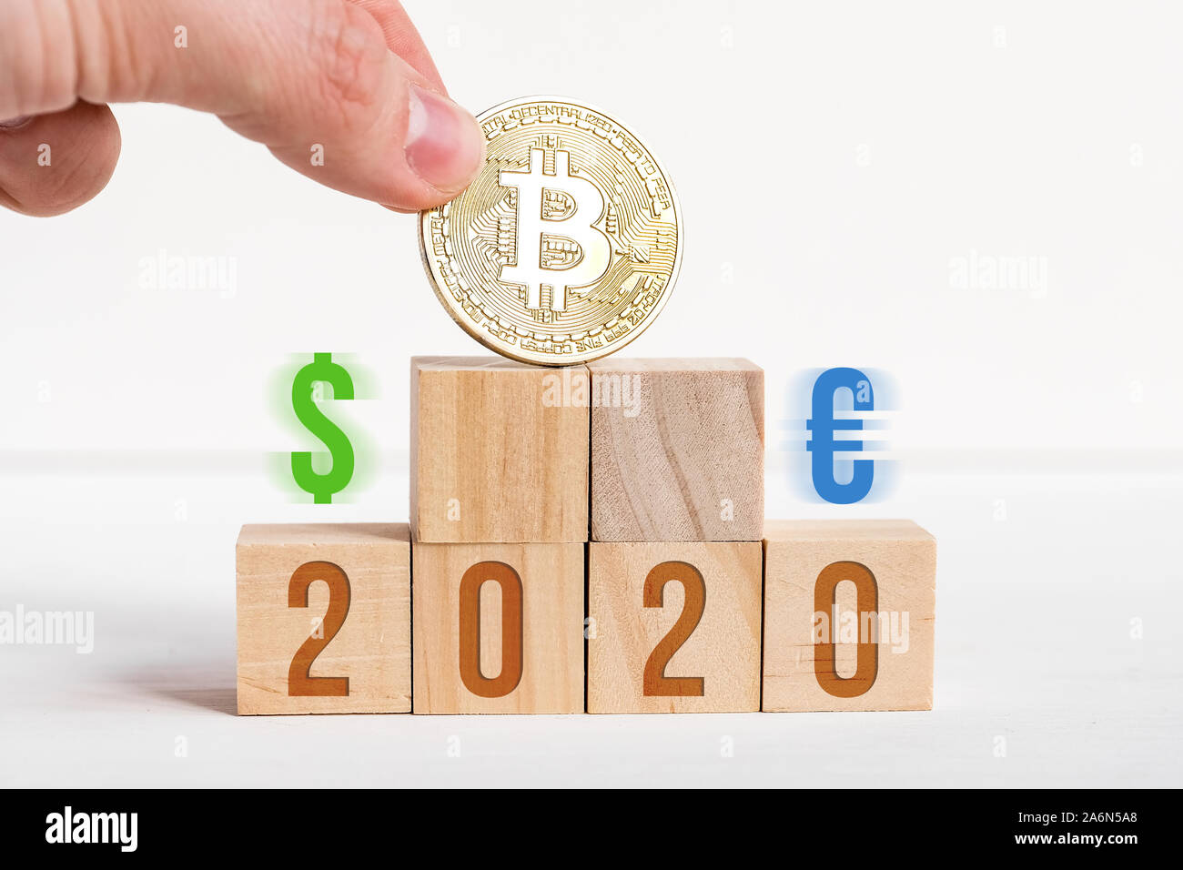 2020 Nummern auf holzwürfel auf weißem Hintergrund neben Bitcoin, Dollar, Euro. Der Begriff Prävalenz von cryptocurrency über das Übliche. Close Up. Stockfoto