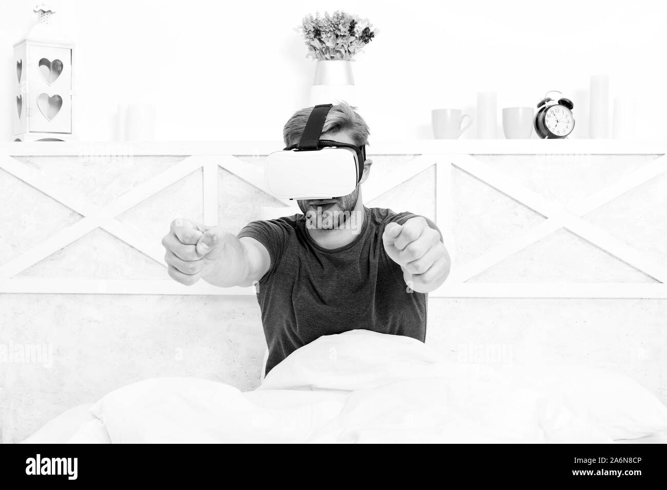 Das Spiel ist auf. Spiel Entwickler oder Gamer. Hübscher Kerl tragen VR-Brillen für video game. Kaukasische Mann mit Virtual reality Headset genießen Sie spielen pc-Spiel im Bett. Stockfoto