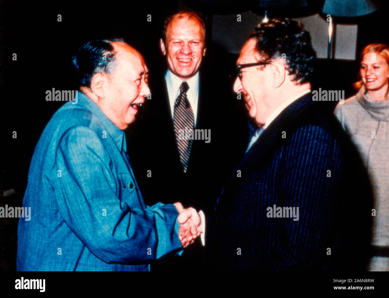 Präsident Gerald Ford und Tochter Susan zusehen, wie Außenminister Henry Kissinger schüttelt Hände mit Mao Tse-Tung - Dezember 2, 1975 Stockfoto