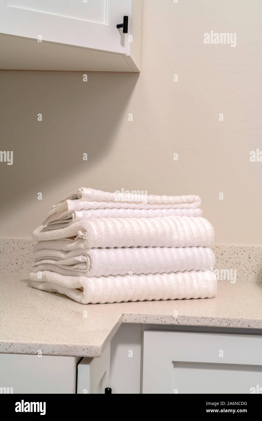 Ordentlich sauber, weiße Handtücher auf Zähler gestapelt Stockfoto