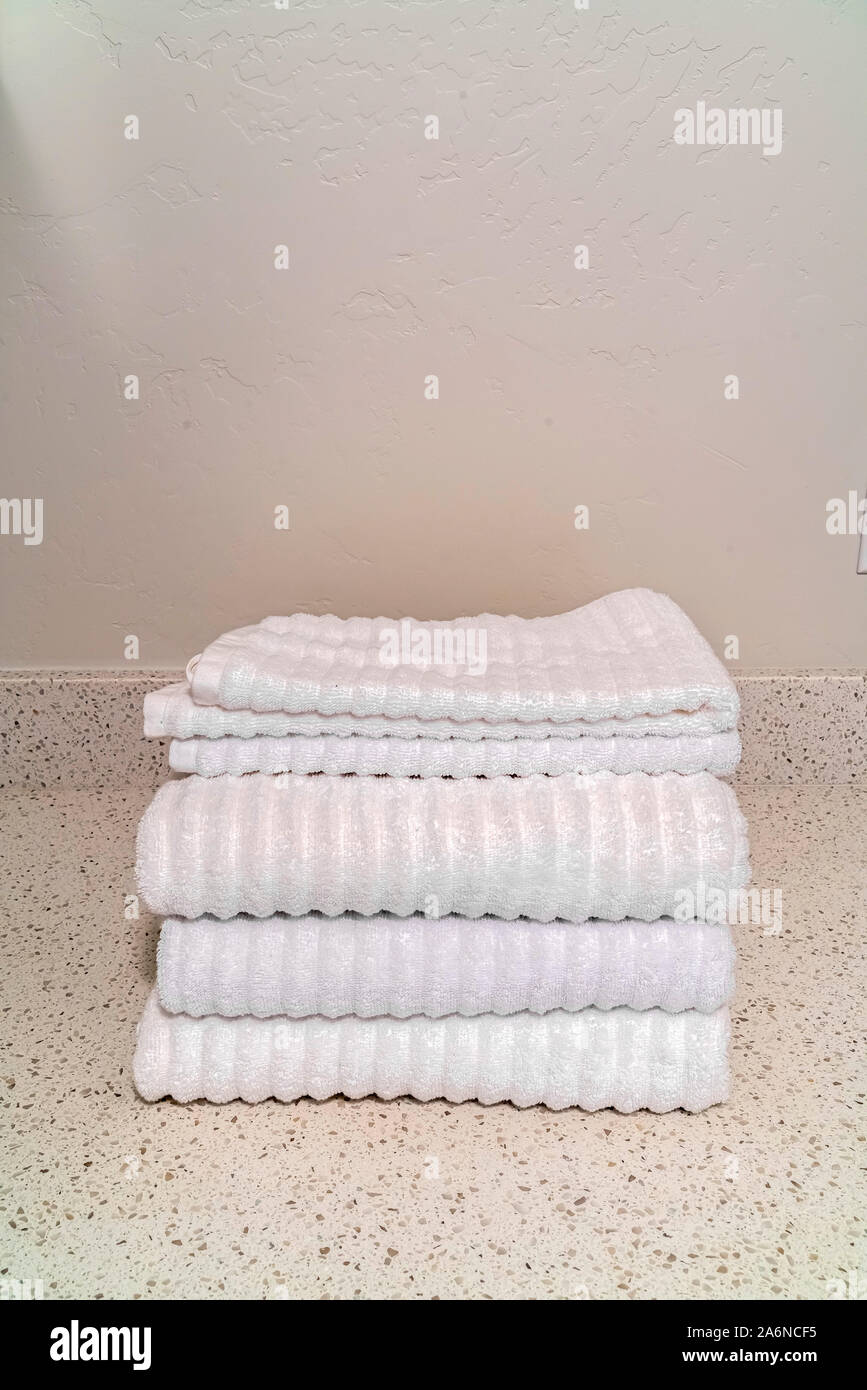 Gefaltete saubere, weiße Handtücher auf einer Marmorplatte Stockfoto