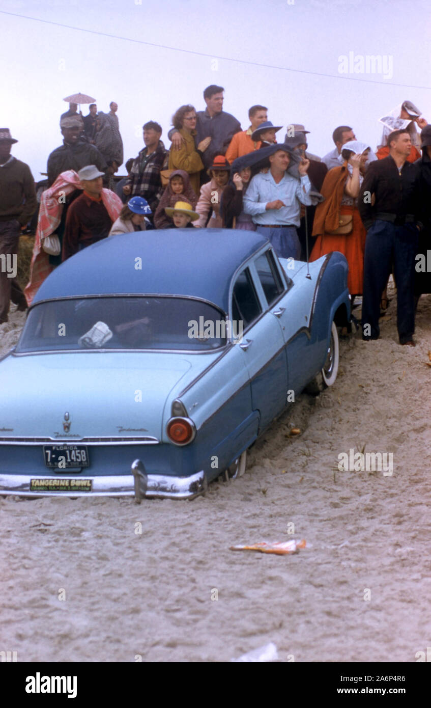 DAYTONA BEACH, FL - 26. Februar: Fans stehen und beobachten Sie die Rennen als Ford Fairlane sitzt im Sand während der NASCAR Daytona Beach 1956 und Straße Kurs Rennen am 26. Februar 1956 in Daytona Beach, Florida. (Foto von Hy Peskin) (Satz Anzahl: X3553) Stockfoto
