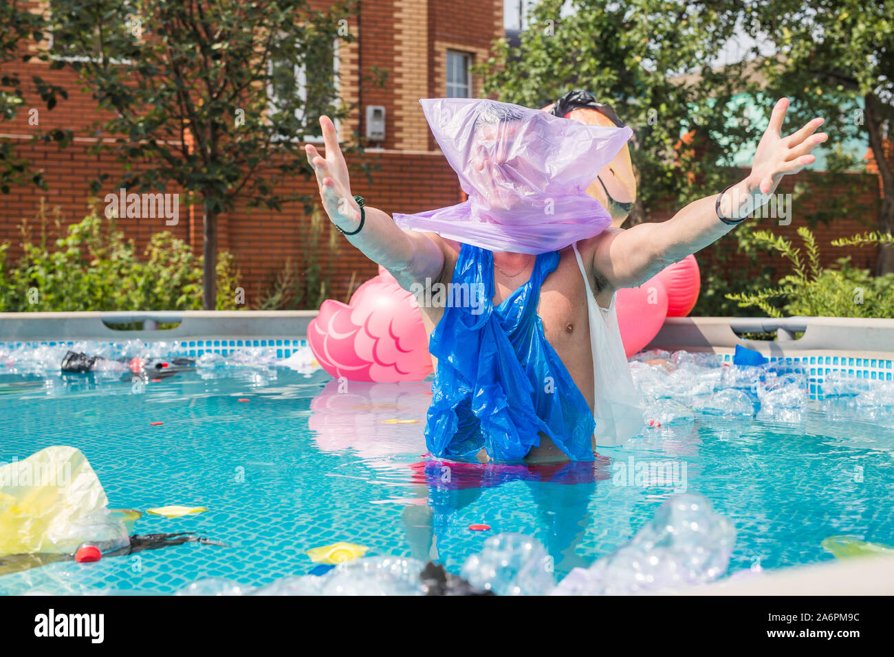 Ökologie, Kunststoff Papierkorb, Umwelt- und Wasserverschmutzung - Schreiende Mann mit einer Plastiktüte über den Kopf in einem dreckigen Pool Stockfoto