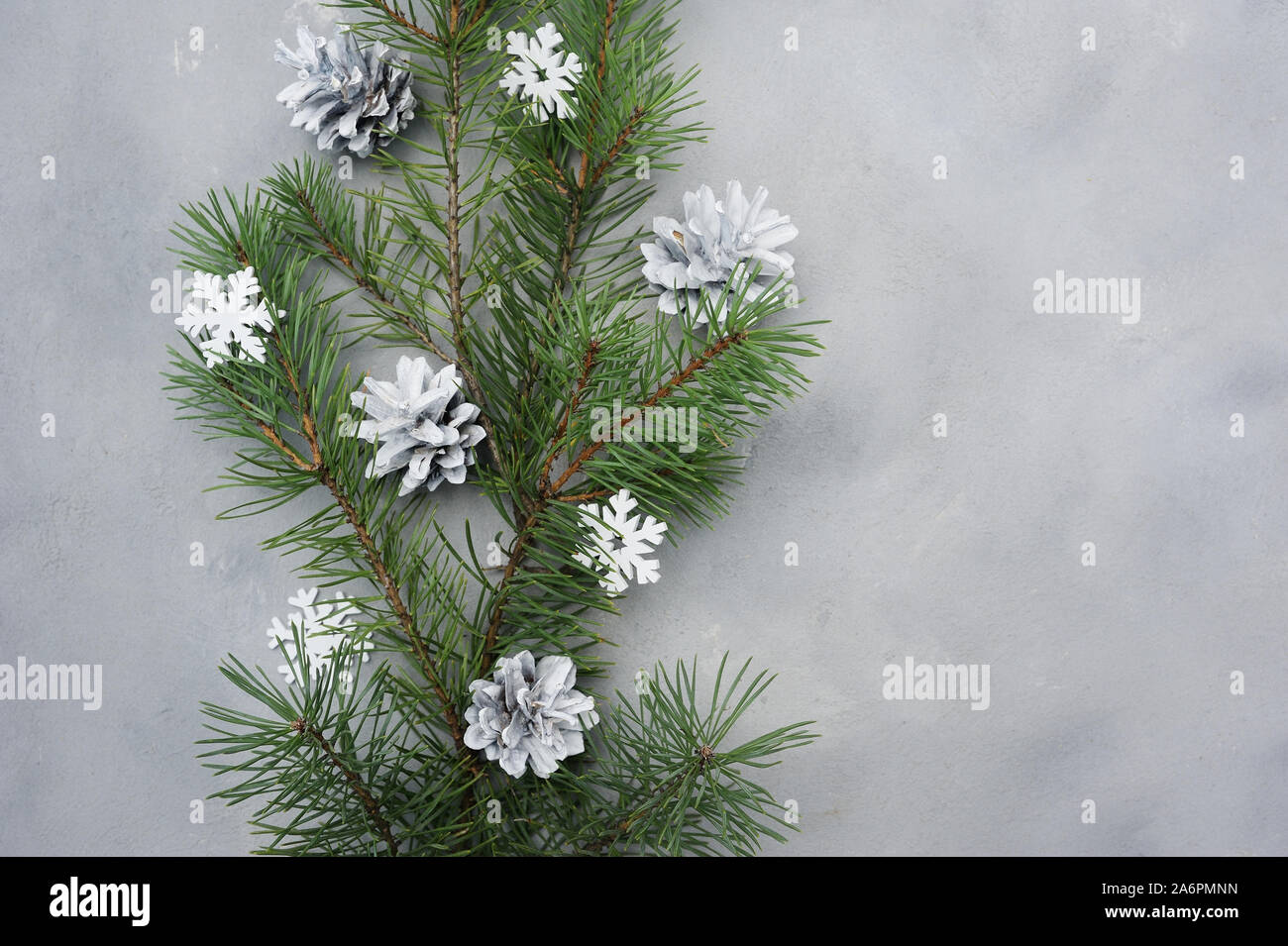 Weihnachten Flach Grußkarte mit Tannenbaum, Zweige und Schneeflocken in grau Holz- Hintergrund. Moderne Komposition für Winterurlaub design Stockfoto