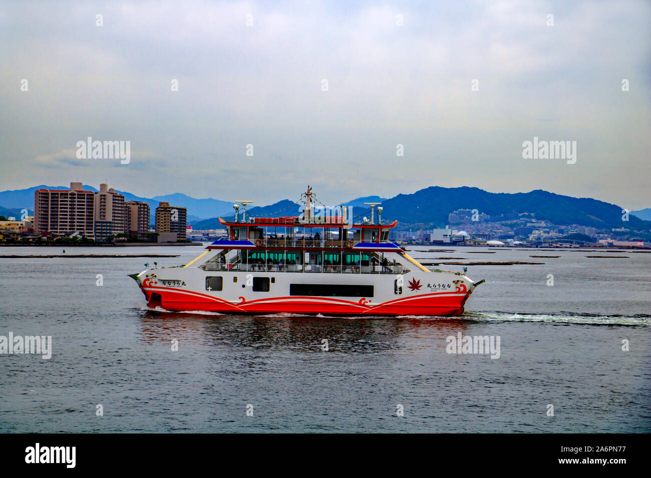 Eine Fähre, Passagiere und Autos über die Seto Binnenmeer von Hiroshima Insel Miyajima in Japan Stockfoto
