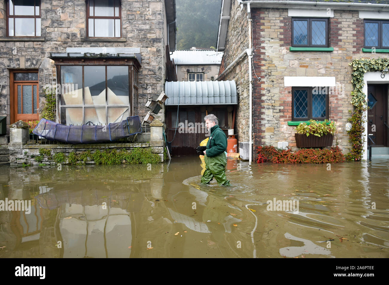 Ein Mann watet durch Hochwasser im unteren Longhope, wo Regen aus der walisischen Hügel und Flut das Dorf, das am Ufer des Flusses Wye sitzt überschwemmt haben, die Sie unpassierbar. Stockfoto