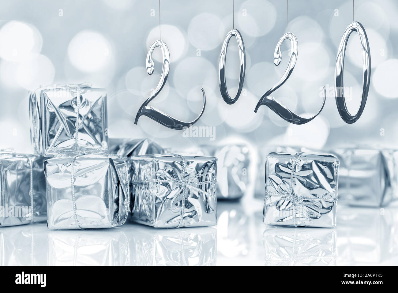 2020, neues Jahr, kleine Weihnachtsgeschenke in glänzendem Silber Papier, bokeh Lichter Hintergrund Stockfoto