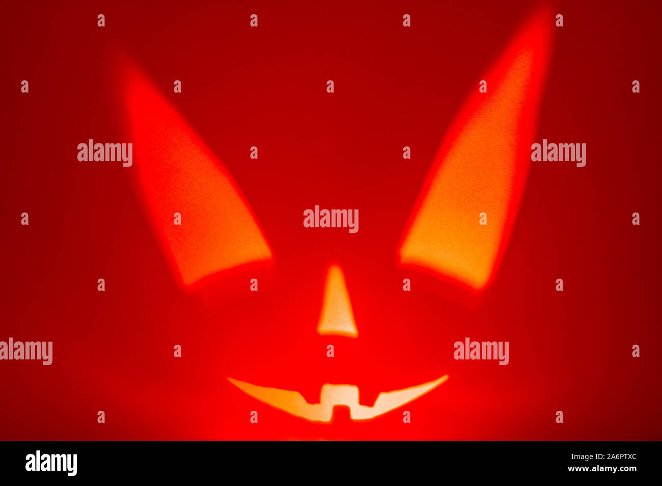 Schatten von Halloween scary pumpkin Gesicht auf rotem Papier Hintergrund. Schatten aus dem Feuer. Halloween Horror Hintergrund. Stockfoto