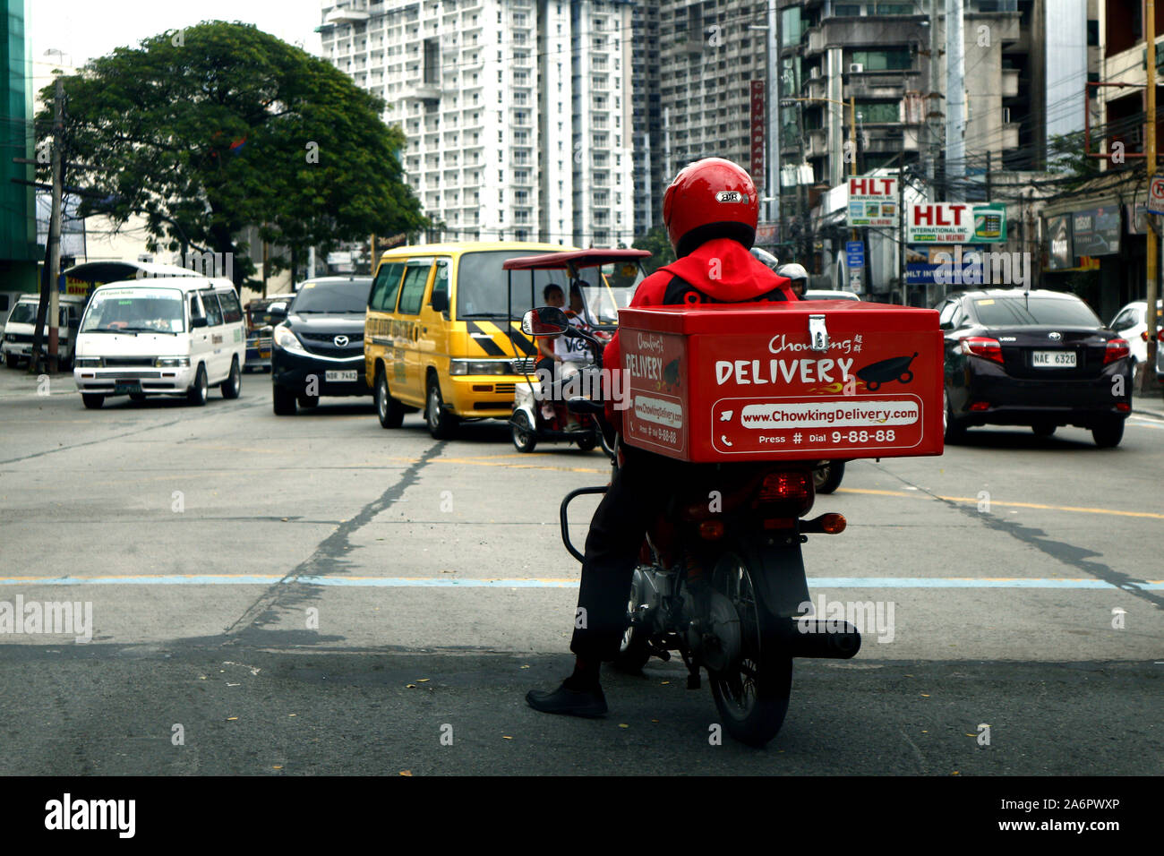 ANTIPOLO CITY, Philippinen - Oktober 9, 2019: Motorrad essen Lieferung Fahrer warten, bis die Ampel an einer Kreuzung zu Grün. Stockfoto