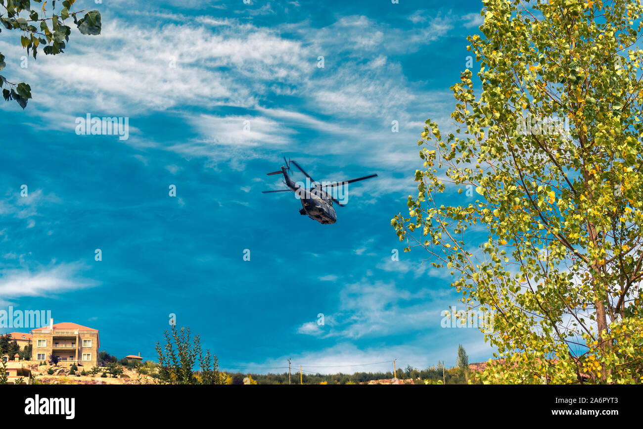 Moderne taktische Hubschrauber weg fliegen. Der Häcksler ist mit neuer Technologie für taktische Kriegsführung gefüllt. Bewölkt blauer Himmel im Hintergrund. Stockfoto