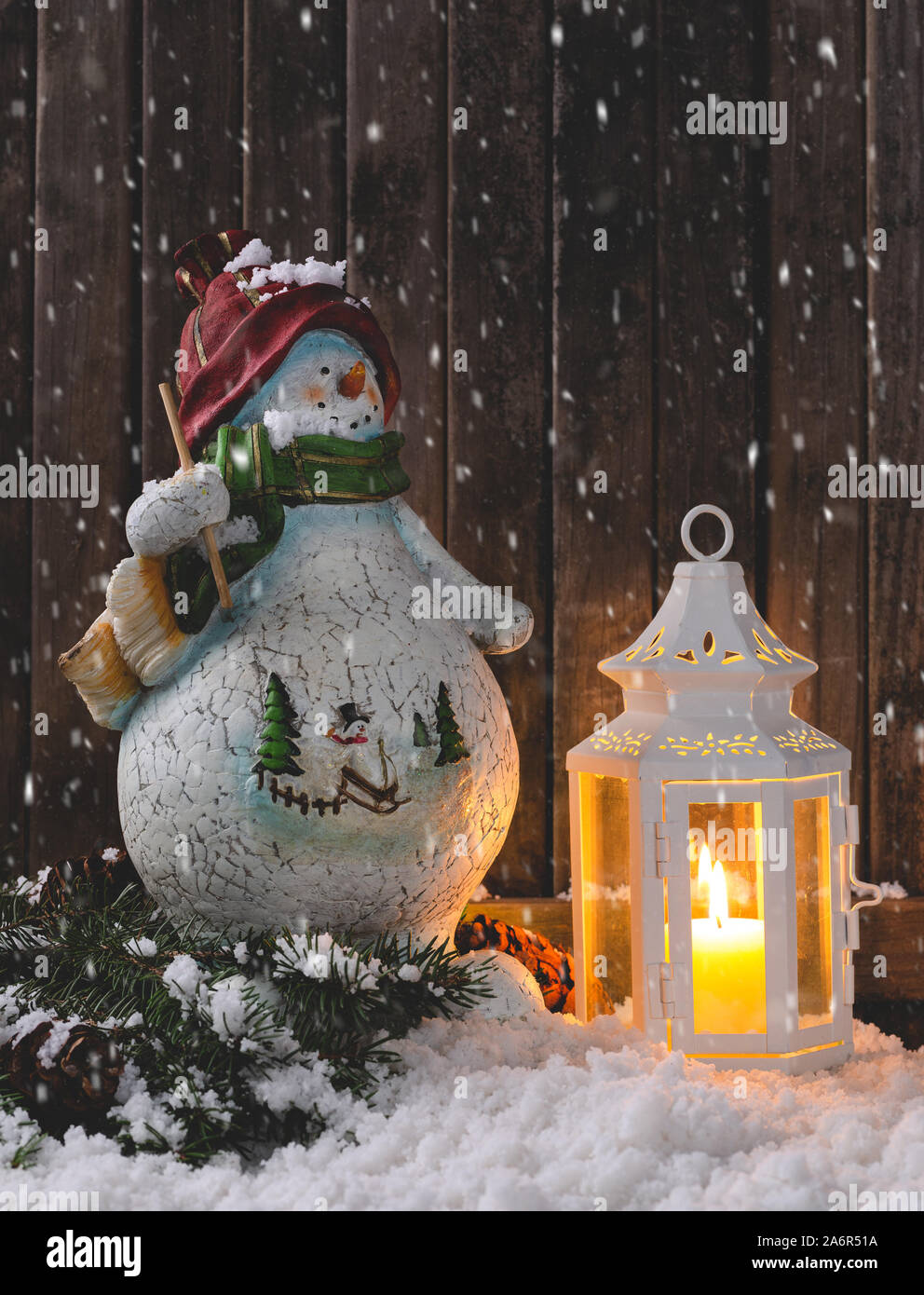 Schnee Winter Szene mit Ferienwohnung Schneemann und leuchtende Laterne auf  rustikalen Holzmöbeln Hintergrund mit Kopie Raum Stockfotografie - Alamy