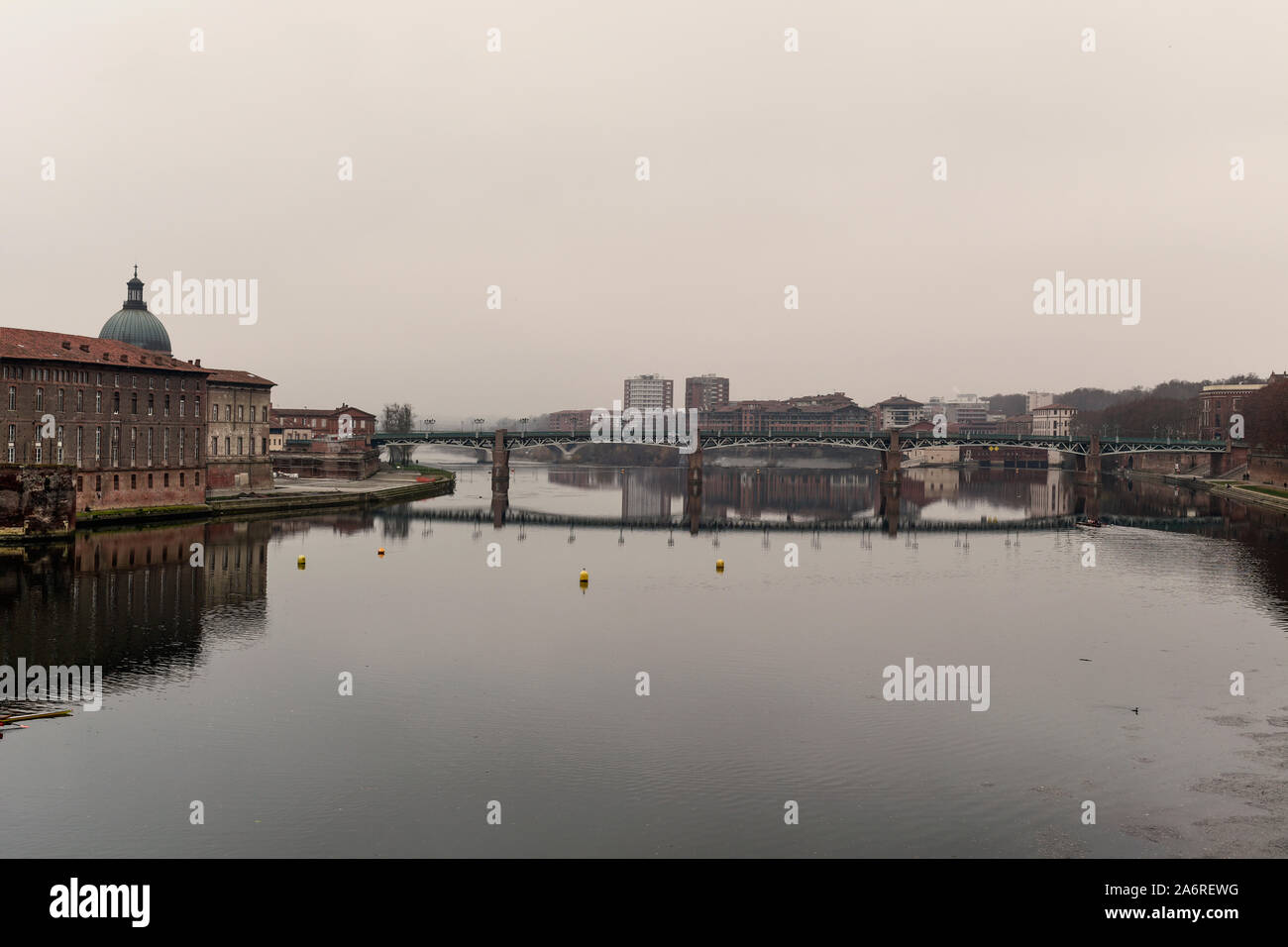 Ein Blick auf den Fluss Garonne, wie es durch Toulouse, Frankreich vergeht, in einem nebligen Tag mit der Brücke Pont Saint Pierre in den Hintergrund und die Hotel-Di Stockfoto