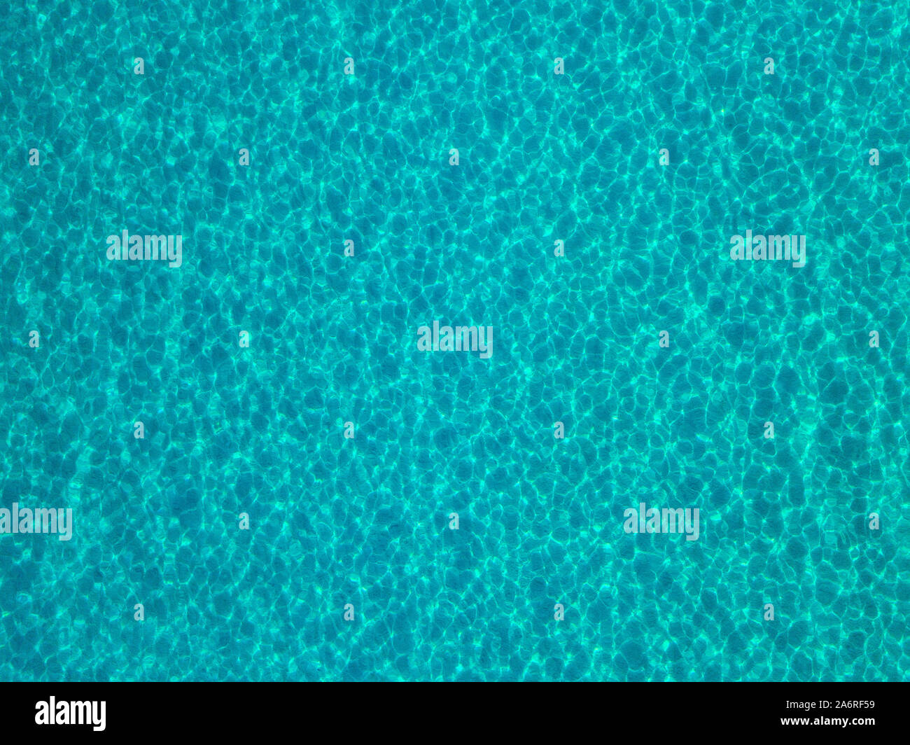 Luftaufnahme von einem sandigen Meeresboden, kristallklares blaues Wasser, Reflexionen der Sonne Wellen auf der Wasseroberfläche. Textur und Hintergrund. Pool Stockfoto