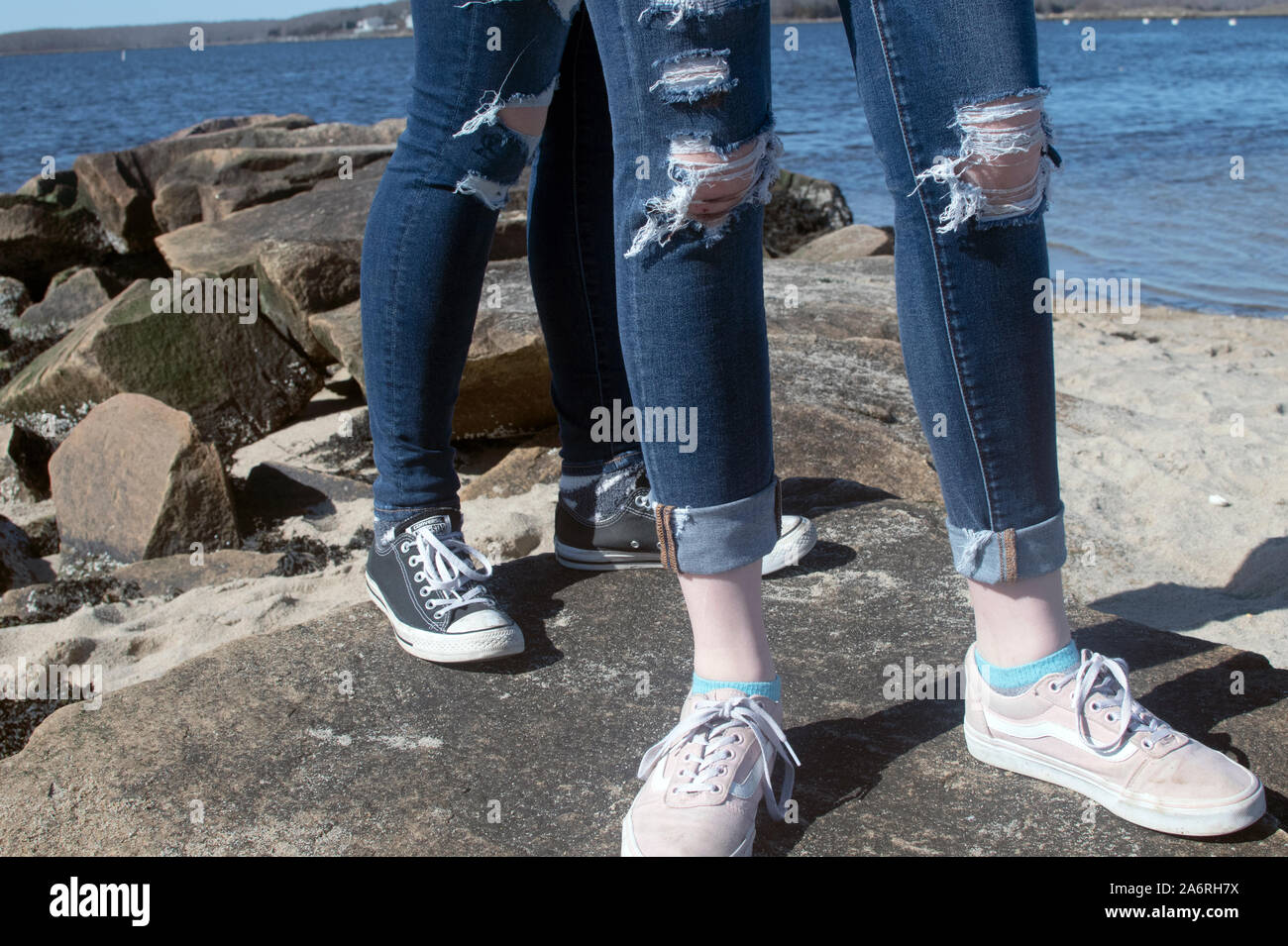 Jeans Beine mit Bohrungen und Wasser Hintergrund Stockfoto