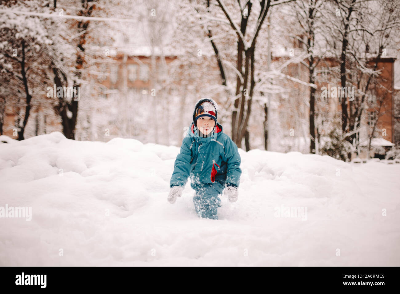Glückliche junge spielt im Schnee im Winter Stockfoto