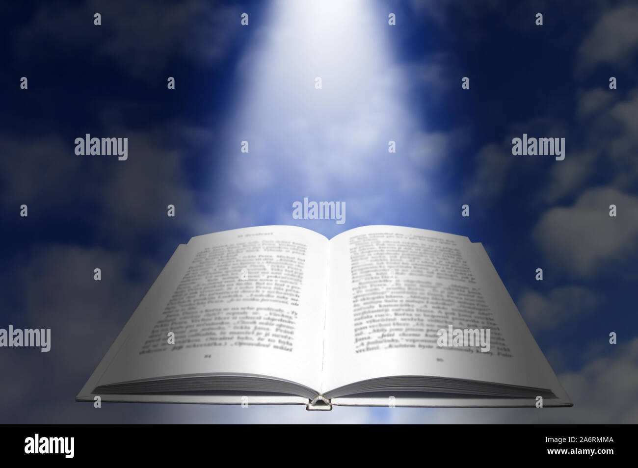 Offenes Buch schweben über einem blauen Himmel mit dem göttlichen Licht herab fallende Stockfoto