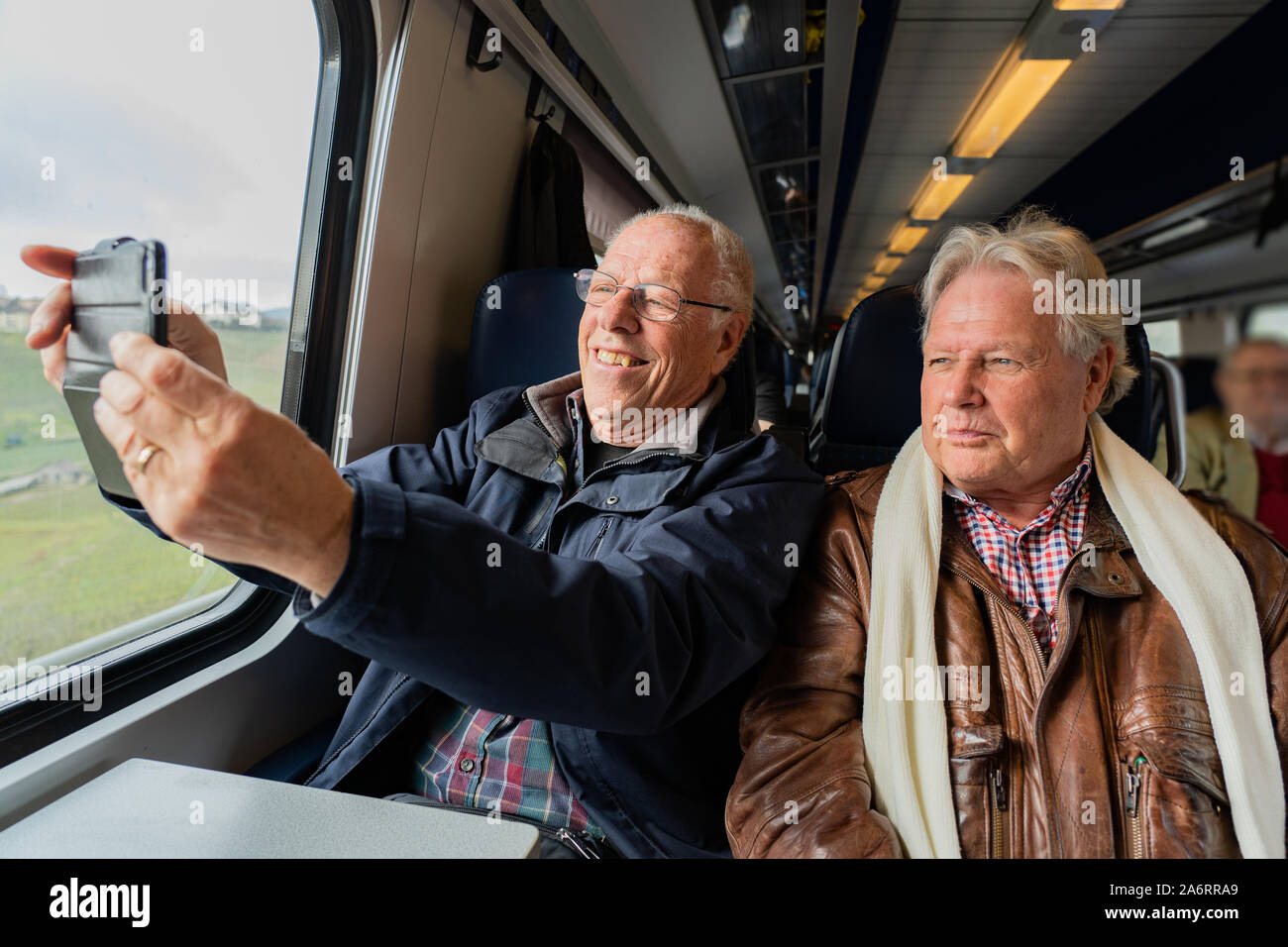 Ältere Menschen mit einem guten Freund in Freizeitkleidung ist ein Selbstportrait mit einem smart phone in Zug in der Schweiz bei Tageslicht. Stockfoto