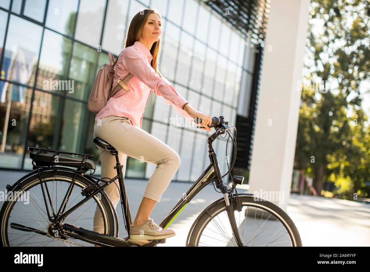 Junge Frau mit Tablet und e-Bike im Freien an einem sonnigen Tag Stockfoto
