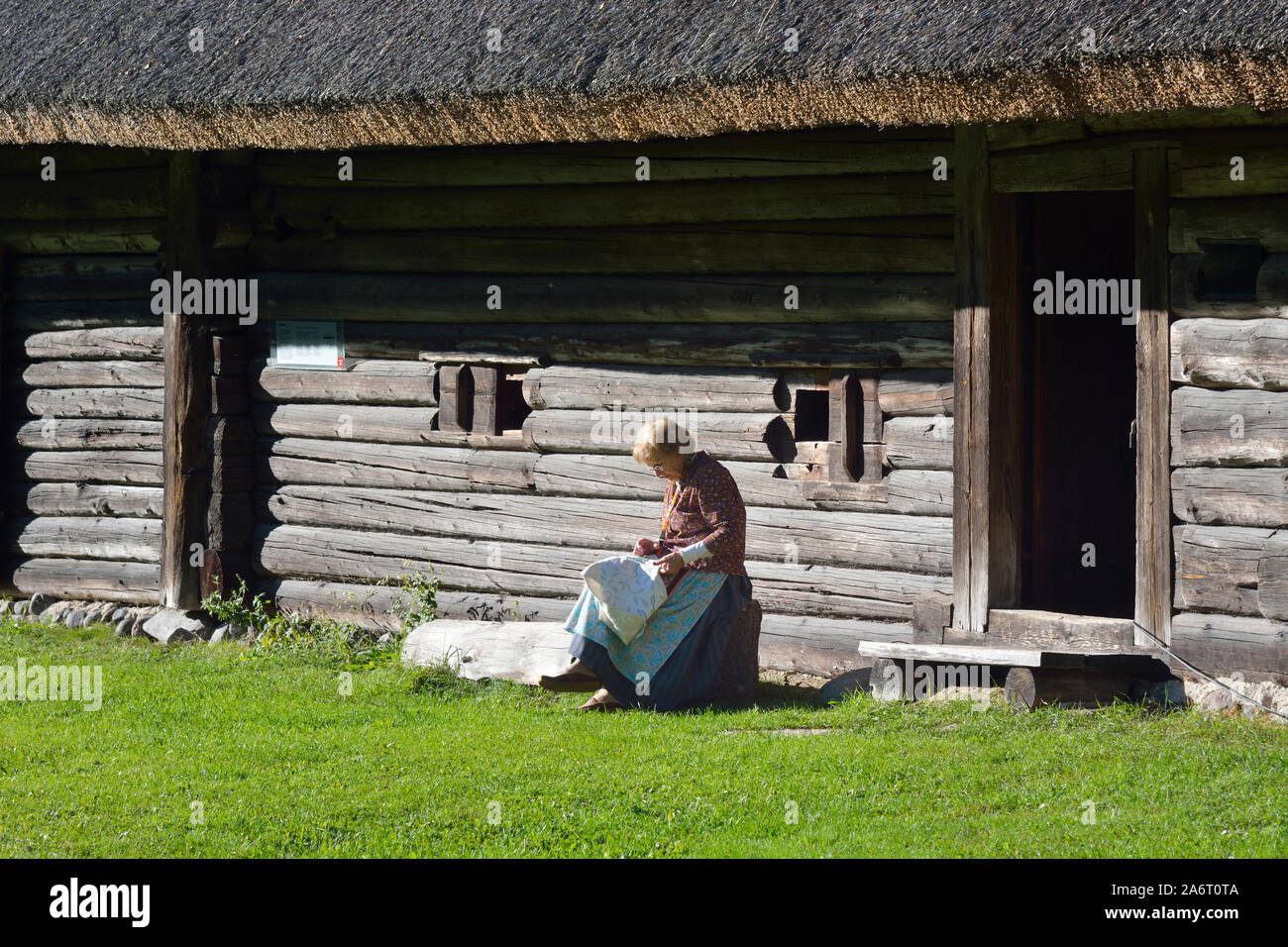 Frau, die Stickerei in einem Bauernhaus. Estnische Freilichtmuseum Rocca Al Mare. Tallinn, Estland Stockfoto