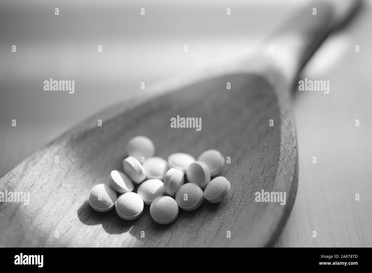Medizinische Pillen in einem holzlöffel Nahaufnahme. Schwarze und weiße poto. Stockfoto