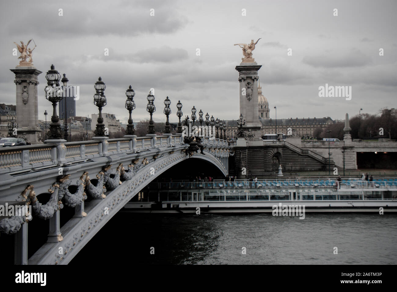 Seitenansicht der Brücke Alexander III über Seine in Paris mit Bateau Mouche vorbei unter it-bewölkten Tag in der Pariser City National Pala Stockfoto