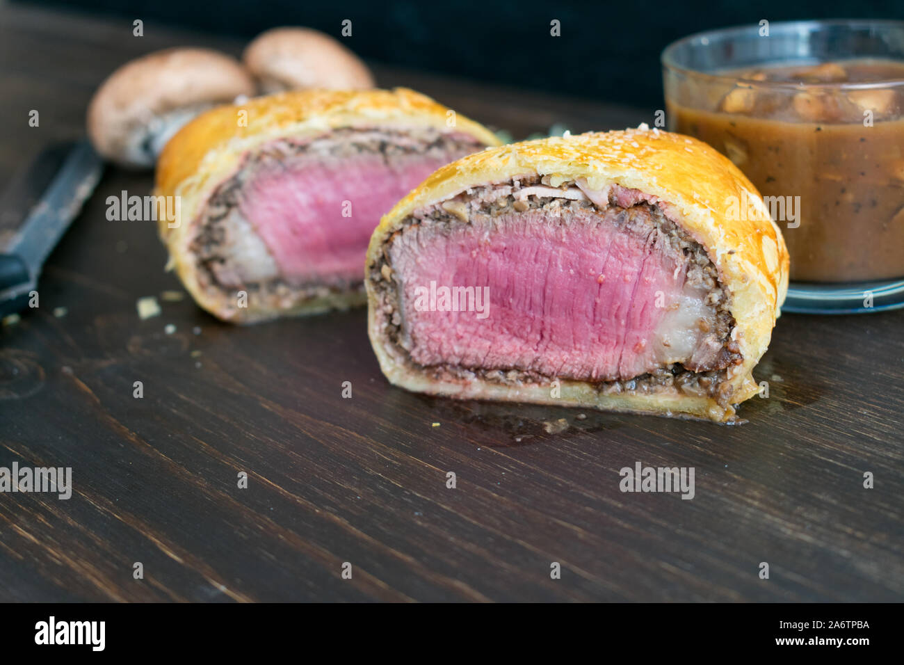 Einzelnen Beef Wellington mit Pilzsauce: Filet Mignon in Schinken gewickelt, cremini Pilz, und Blätterteig Stockfoto