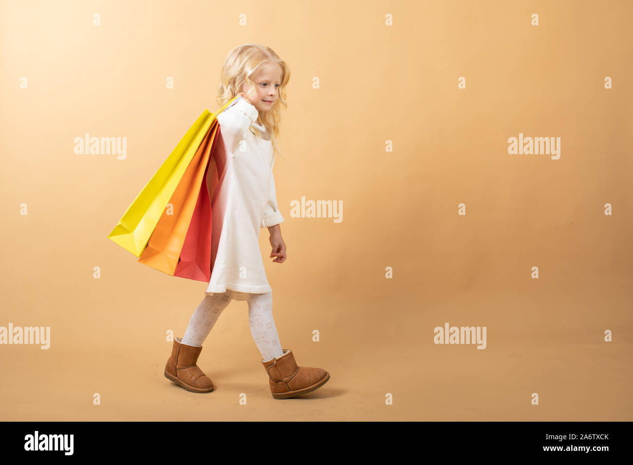 Ein junges Mädchen in einem weißen Kleid und mit Einkaufstüten, Happy Shopping Stockfoto