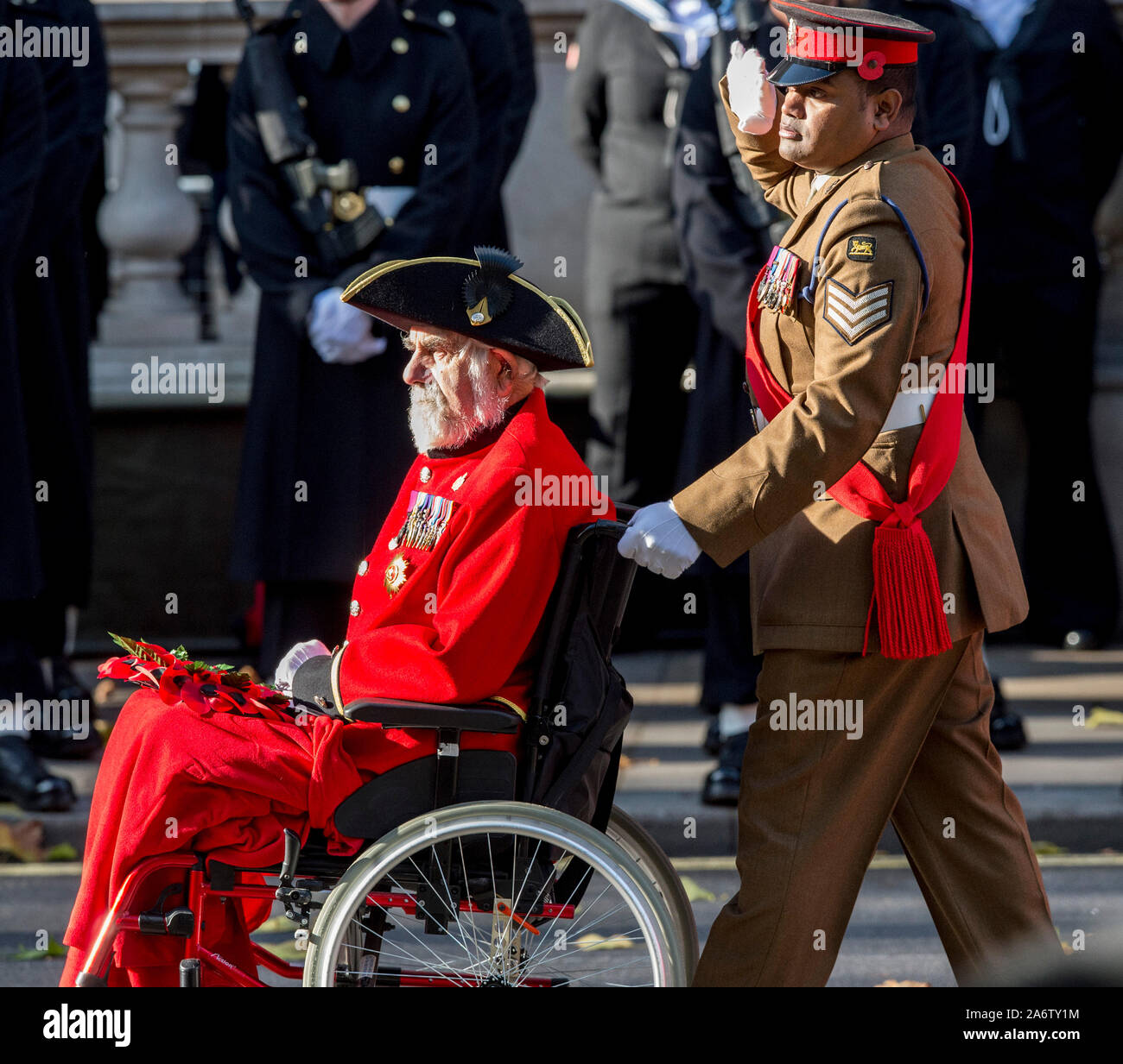Victoria Cross Empfänger William Speakman (Chelsea Rentner) in seinem Rollstuhl geschoben, die von den Kolleginnen und Empfänger Johnson Beharry, vorbei marschierenden Ihre Majestät die Königin und der Herzog von Edinburgh mit anderen Mitgliedern der britischen Royal Family, die sich melden Sie politische Führer und Mitglieder der öffentlichkeit für Trauerfeier bei einer Kranzniederlegung am Ehrenmal in Whitehall, London, England. November 2017. Stockfoto