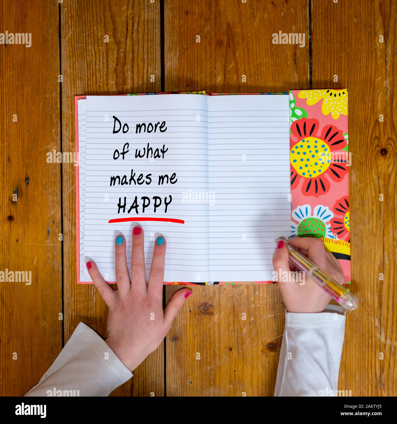 Junge Mädchen schreiben die Worte "Mehr o Was macht mich glücklich in einem vintage Tagebuch' Stockfoto