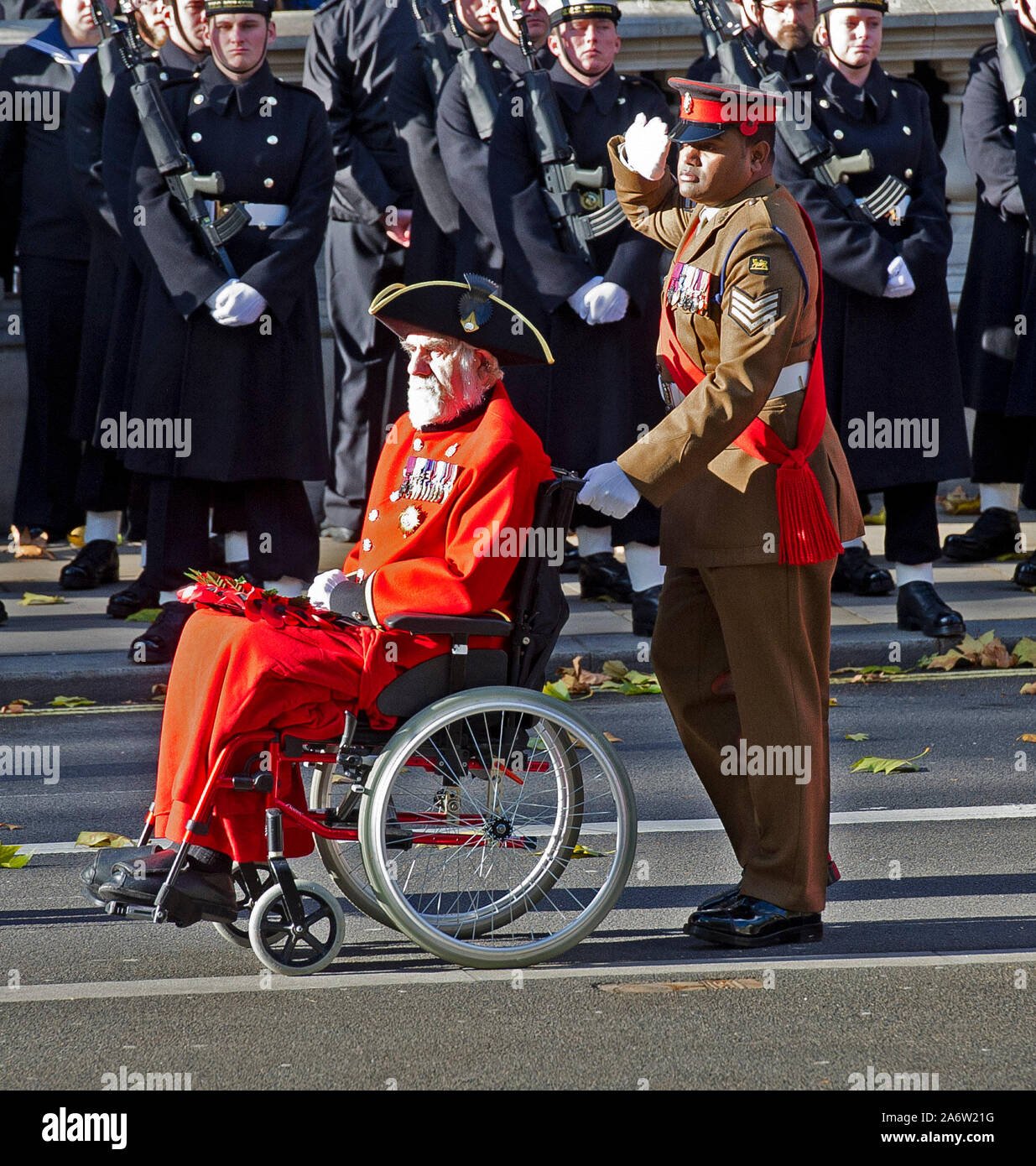 Victoria Cross Empfänger William Speakman (Chelsea Rentner) in seinem Rollstuhl geschoben, die von den Kolleginnen und Empfänger Johnson Beharry, vorbei marschierenden Ihre Majestät die Königin und der Herzog von Edinburgh mit anderen Mitgliedern der britischen Royal Family, die sich melden Sie politische Führer und Mitglieder der öffentlichkeit für Trauerfeier bei einer Kranzniederlegung am Ehrenmal in Whitehall, London, England. November 2017. Stockfoto