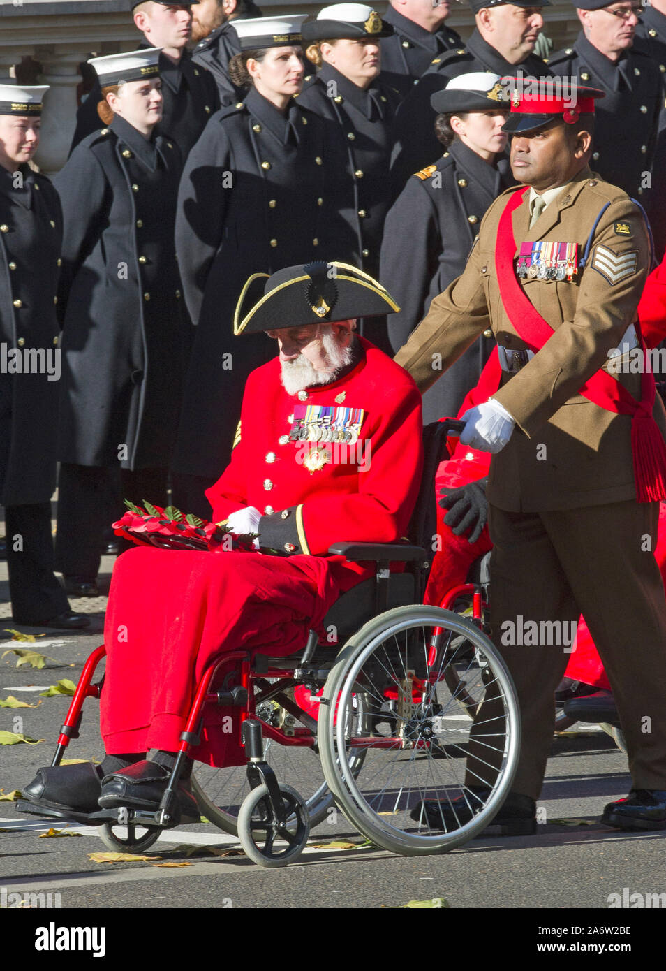 Victoria Cross Empfänger William Speakman (Chelsea Rentner) in seinem Rollstuhl geschoben, die von den Kolleginnen und Empfänger Johnson Beharry, vorbei marschierenden Ihre Majestät die Königin und der Herzog von Edinburgh mit anderen Mitgliedern der britischen Royal Family, die sich melden Sie politische Führer und Mitglieder der öffentlichkeit für Trauerfeier bei einer Kranzniederlegung am Ehrenmal in Whitehall, London, England. November 2017. Stockfoto