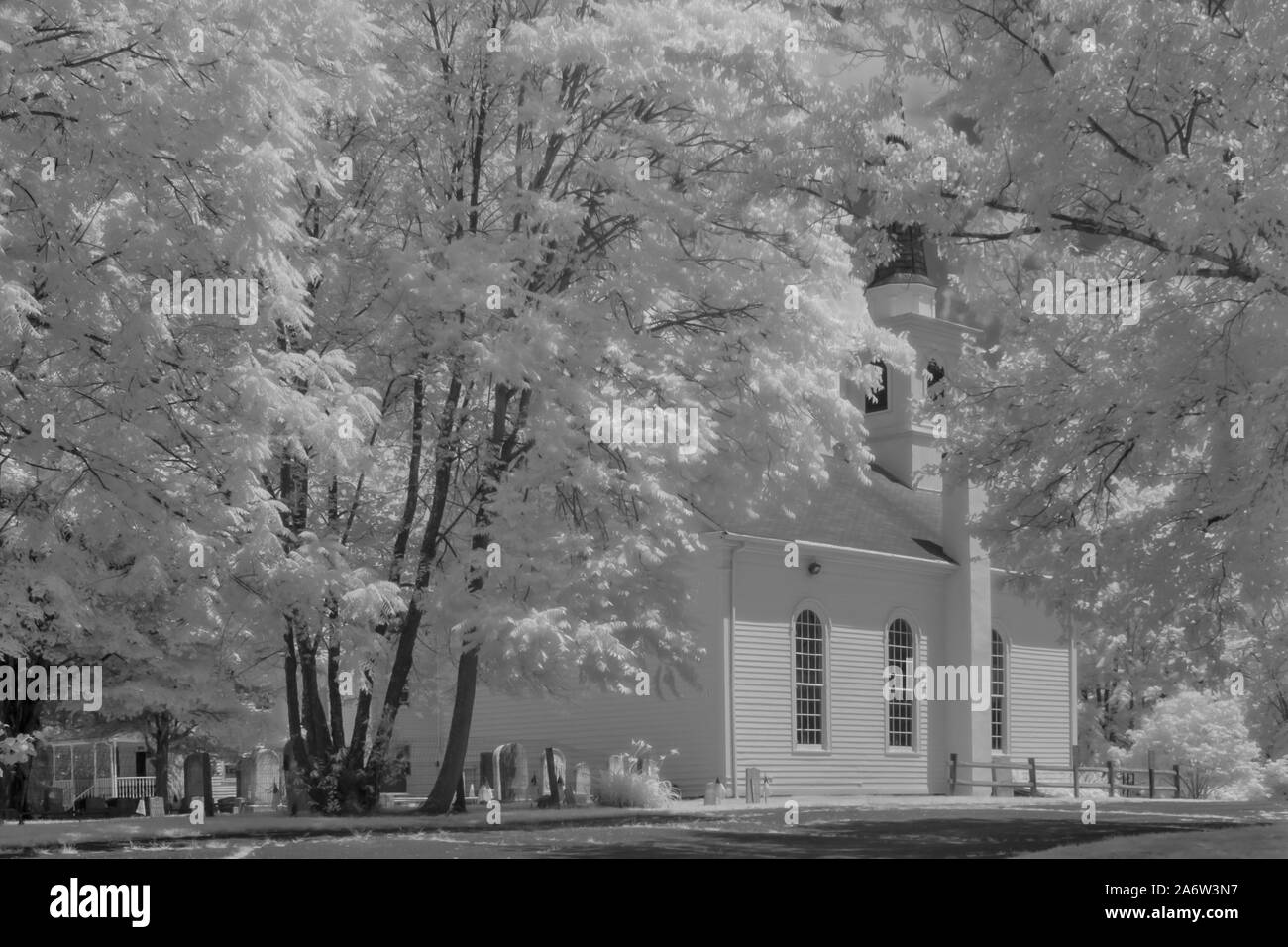 Dorf Kapelle - Schwarz und Weiß infrarot Ansicht auf eine mehr als hundert Jahre alten, restaurierten Vereinigte Methodistische Kirche, Kirchturm und Friedhof cemeter Stockfoto