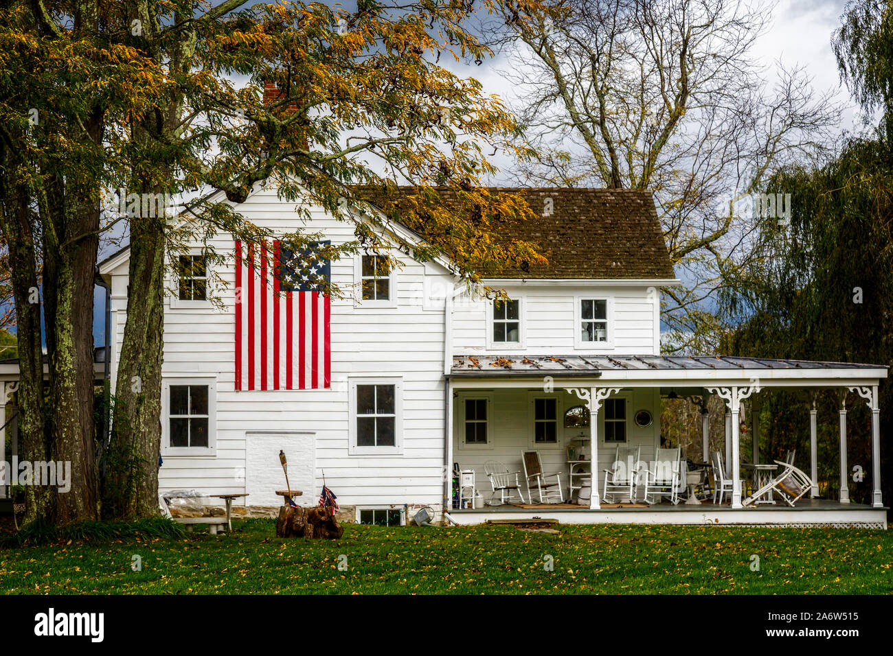 Ländliche Amerika - zu einem patriotischen Land Home im Hudson Valley Gegend von New York, mit einem großen amerikanischen Flagge auf der Seite mit Veranda. Stockfoto
