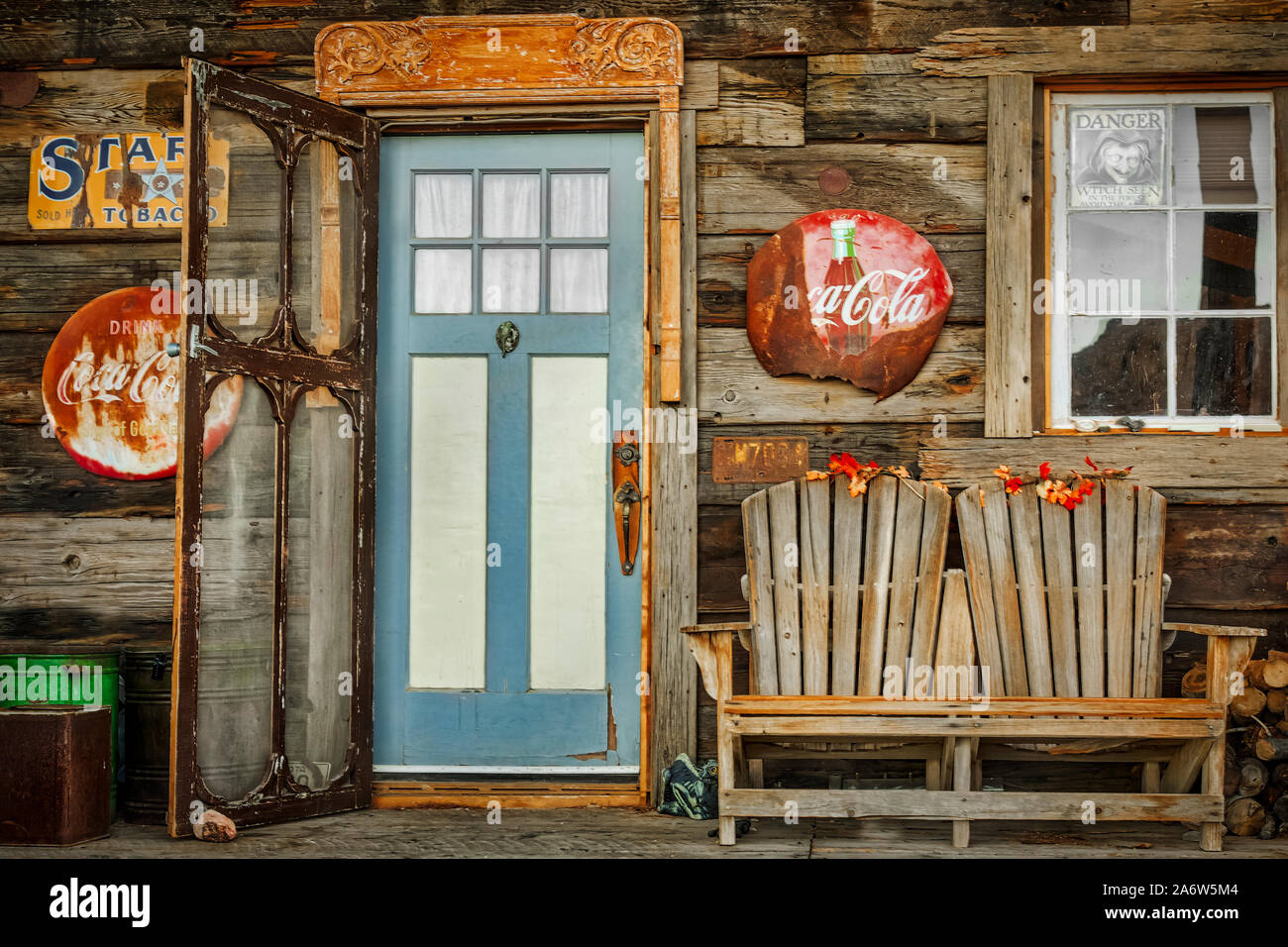 General Store Eingang - Vintage Coca Cola und Star Tabak verkauft hier Schildern entlang mit rustikalem Holz Werkbank, Dosen und Brennholz. Stockfoto