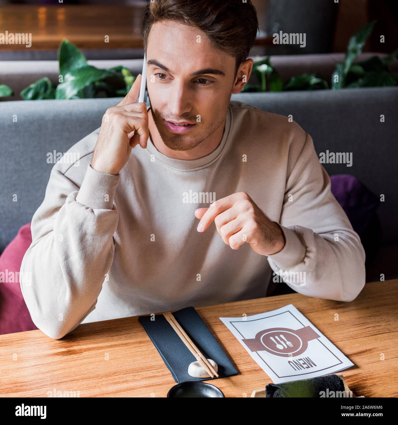 Schöner Mann reden auf dem Smartphone in der Sushi Bar Stockfoto
