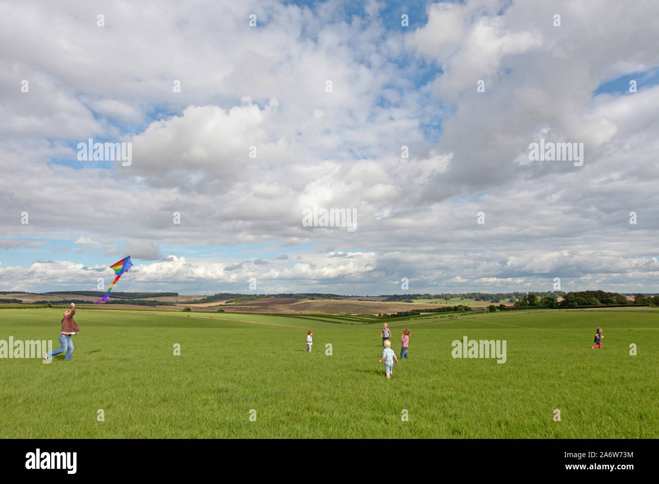 Kinder flying a Kite auf offenen Feldern, England Stockfoto