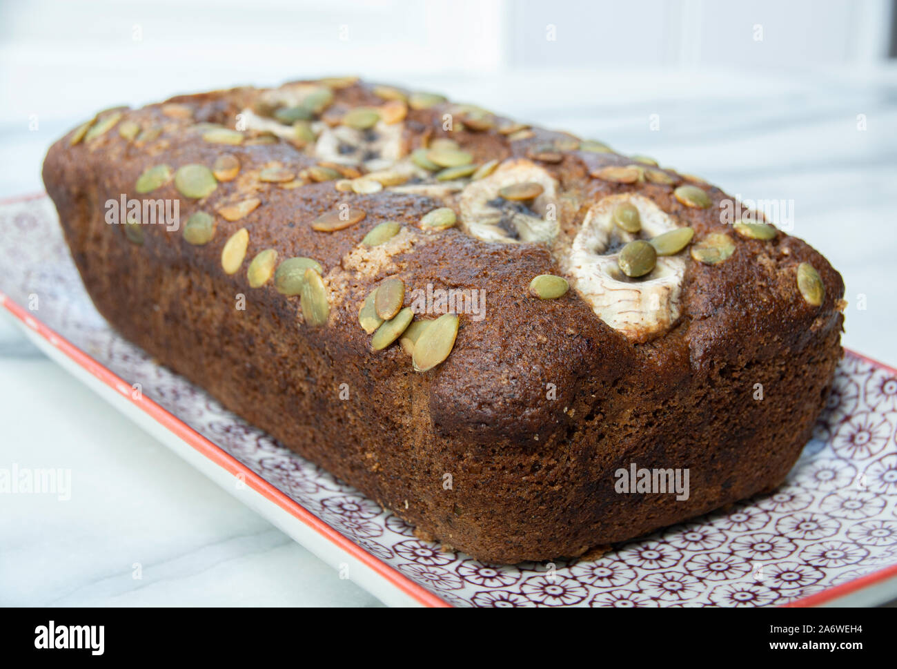 Erste Bananenkuchen, perfekte Laib Bananenkuchen. Glutenfreie und vegane Kuchen auf einem gemusterten rechteckige Platte Stockfoto