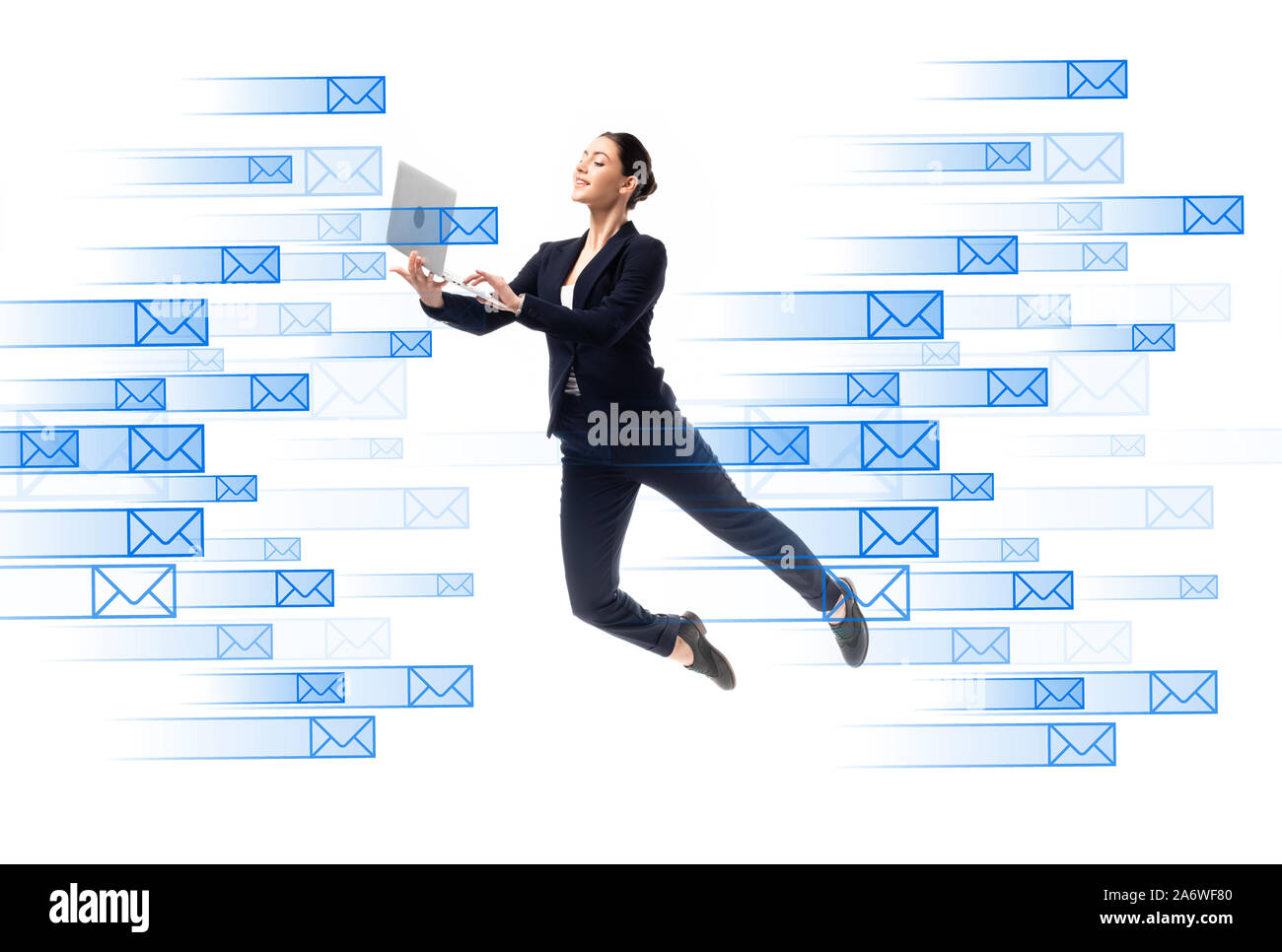 Junge Geschäftsfrau mit Laptop während schwebend in der Nähe von e-mail Icons isoliert auf weißem Stockfoto