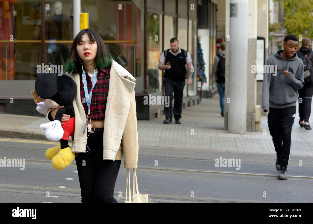 Trendige junge chinesische Mädchen mit Micke Mouse Puppe. Stockfoto