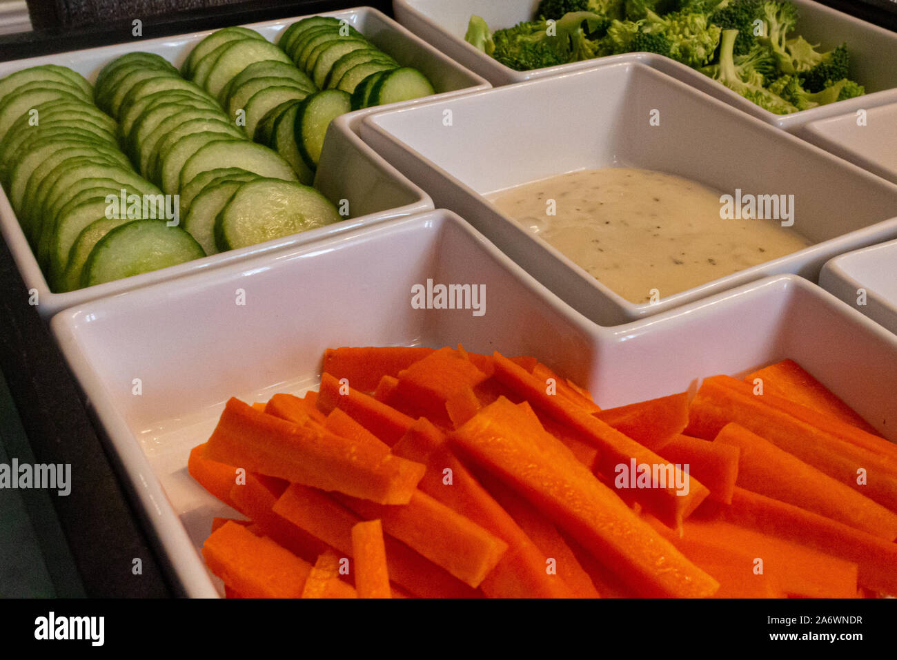 Ein serviertablett bietet rohes Gemüse Gemüse in Weiß, modulare Gerichte. Die Präsentation von Snacks Karotten Sticks, Gurkenscheiben und broccol Stockfoto