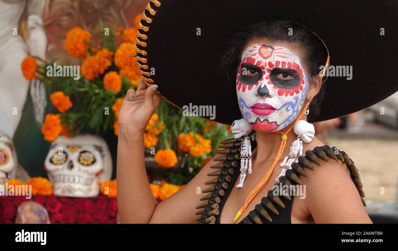Junge Frau mit Sugar Skull Make-up und riesigen SOMBRERO am Dia de los Muertos Veranstaltung an der Mission San Luis Rey. Stockfoto