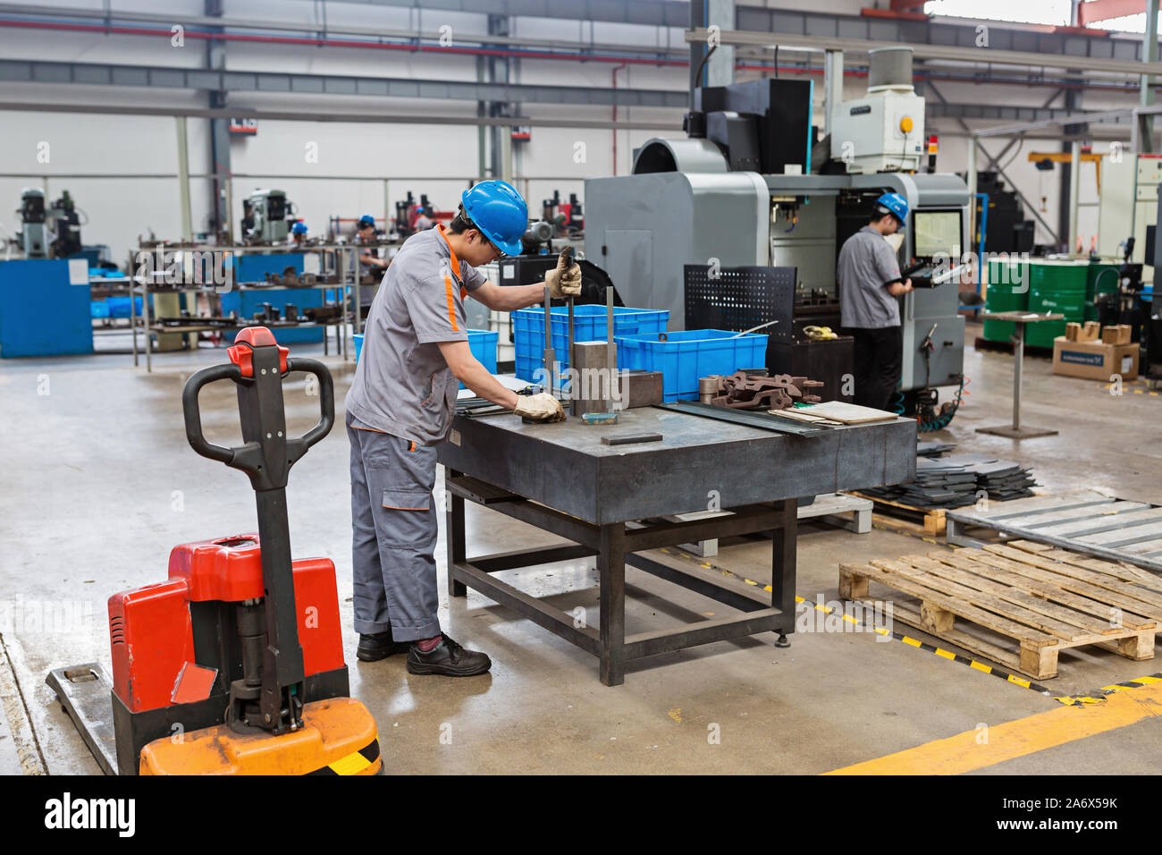 Mitarbeiter arbeiten an der Fabrik an der Maschine. Industrie, Vertrieb, Logistik Import Export, Handel, Versand, Lieferung Konzept Stockfoto