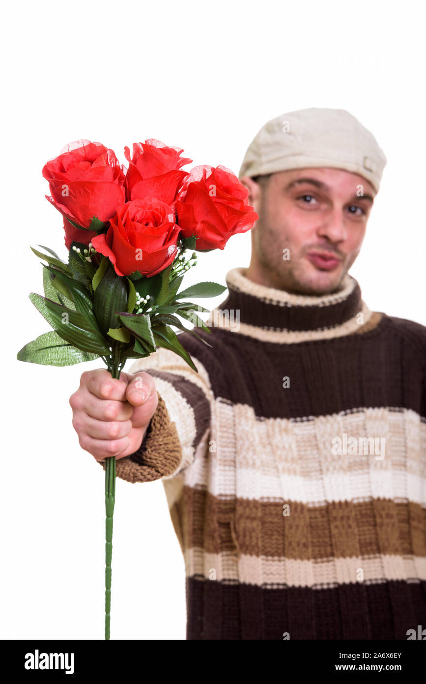 Studio shot junger Mann, der rote Rosen mit Fokus auf rote Rose Stockfoto