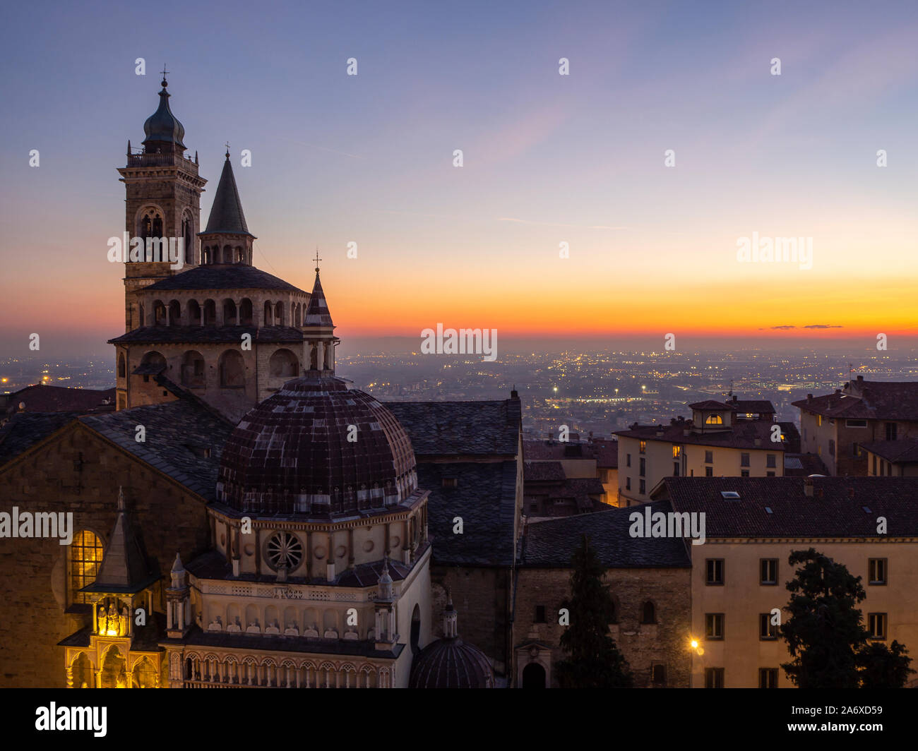 Bergamo, Italien. Die Altstadt. Erstaunlich Luftaufnahme von der Basilika von Santa Maria Maggiore während des Sonnenuntergangs. Im Hintergrund der Po-ebene Stockfoto