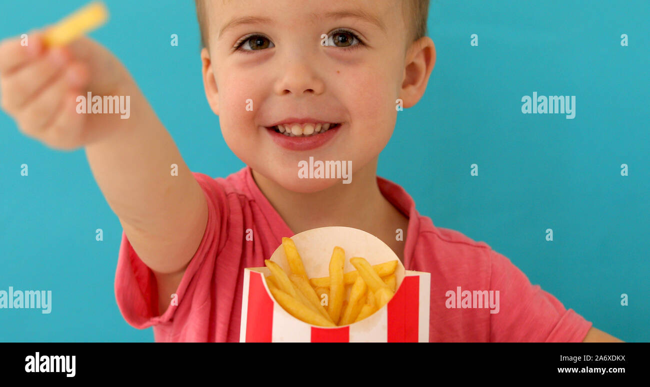 Cute boy sharing Pommes Frites mit Kamera Stockfoto